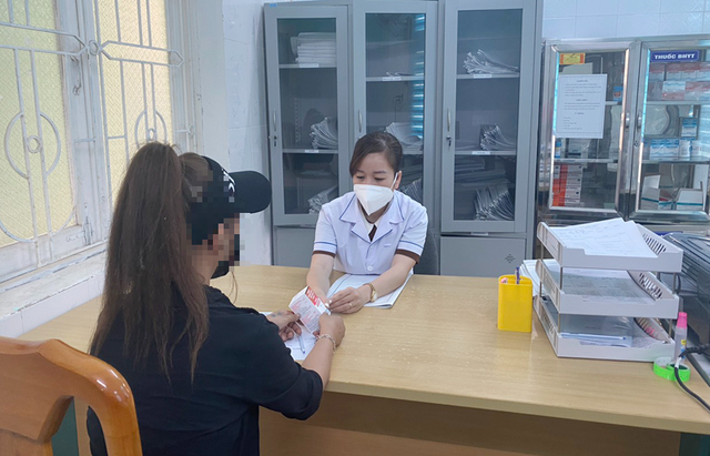 Cán bộ y tế cấp phát thuốc điều trị ARVpng